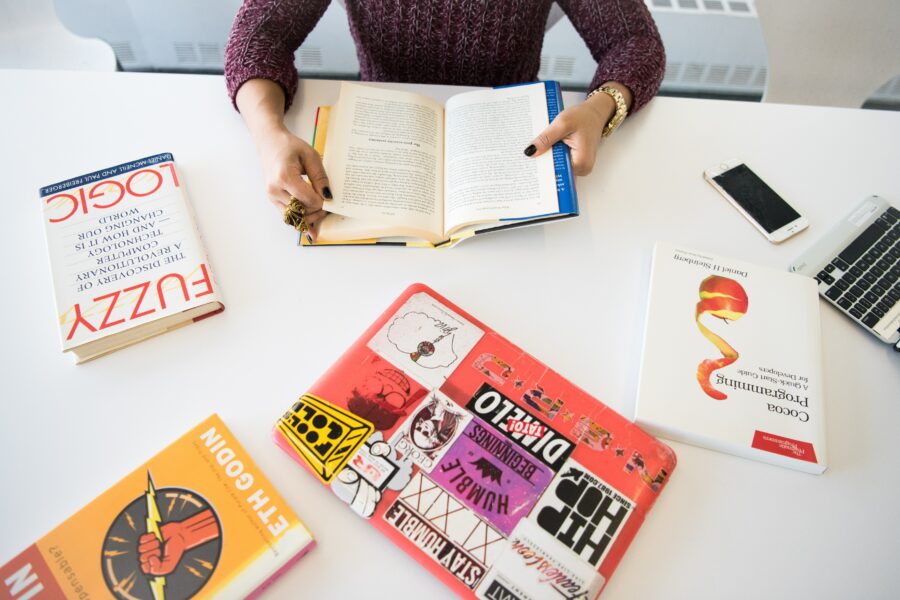 A flat lay of lots of books and papers scattered around, representing creative expression, experimentation and not having to have a linear, forced daily writing practice